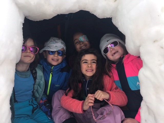 Des enfants jouent dans la neige et construisent leur propre igloo