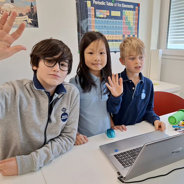 Trois enfants de Vivalys saluant la caméra, ravis de participer à la Semaine des Mathématiques.