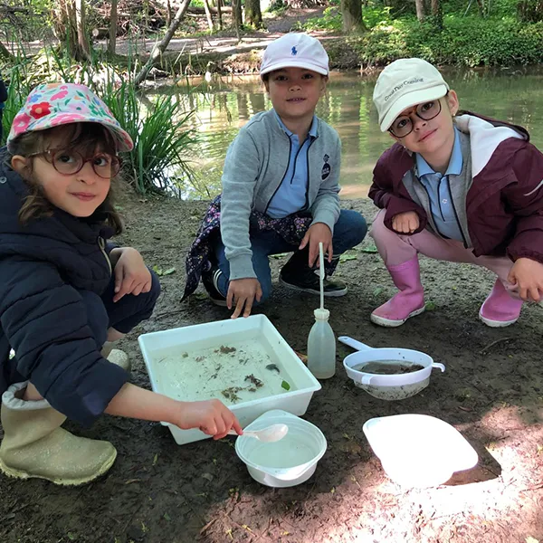 Enfants de l’école Vivalys à Ecublens observant les invertébrés dans la rivière à Tolochenaz