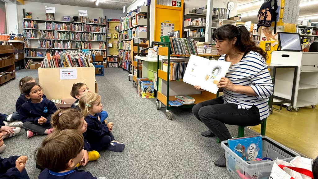 Enfants de la Petite Section Les Petits Acrobates à Lausanne écoutant Julie la conteuse à la bibliothèque de Montriond.