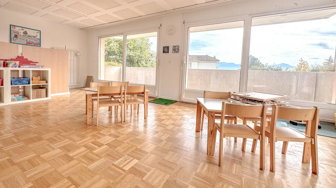 Salle lumineuse de la petite section avec vue sur le lac Léman et les Alpes